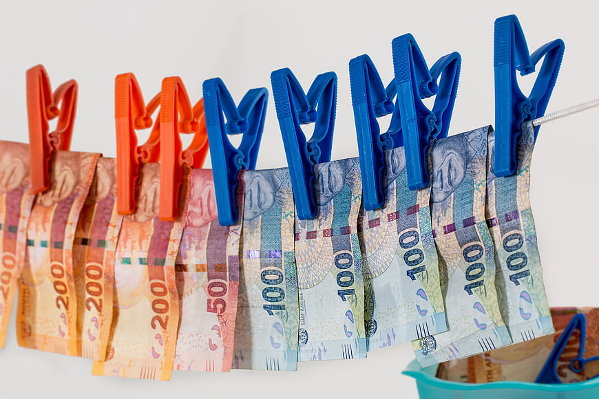 South African Rand banknotes hanging on clothesline with pegs