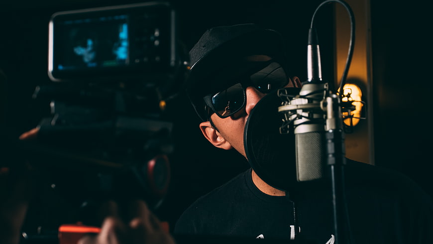 Musician recording in studio with camera filming