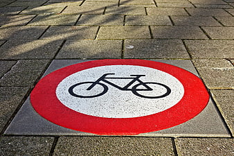 Red and white bicycle prohibition sign on pavement