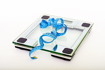 Digital bathroom scale with blue measuring tape on white background