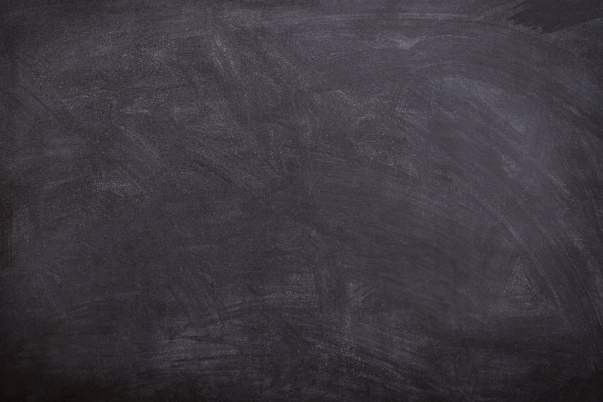 Dark textured blackboard background with chalk dust traces