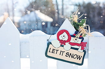 Let It Snow Sign on White Fence in Winter