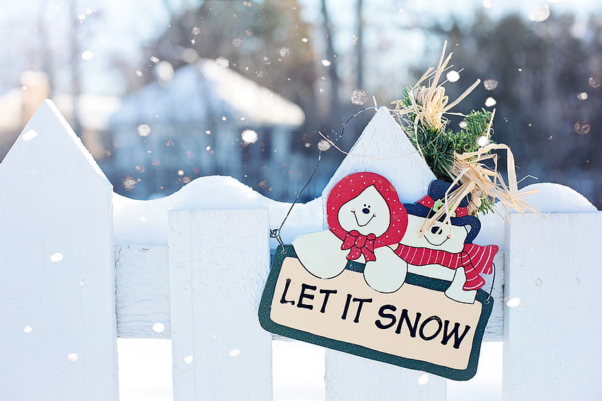 Let It Snow Sign on White Fence in Winter