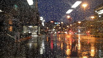 Raindrops on Window with Blurred City Lights at Night