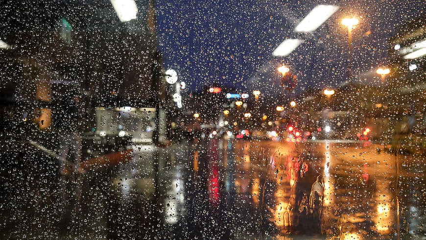 Raindrops on Window with Blurred City Lights at Night