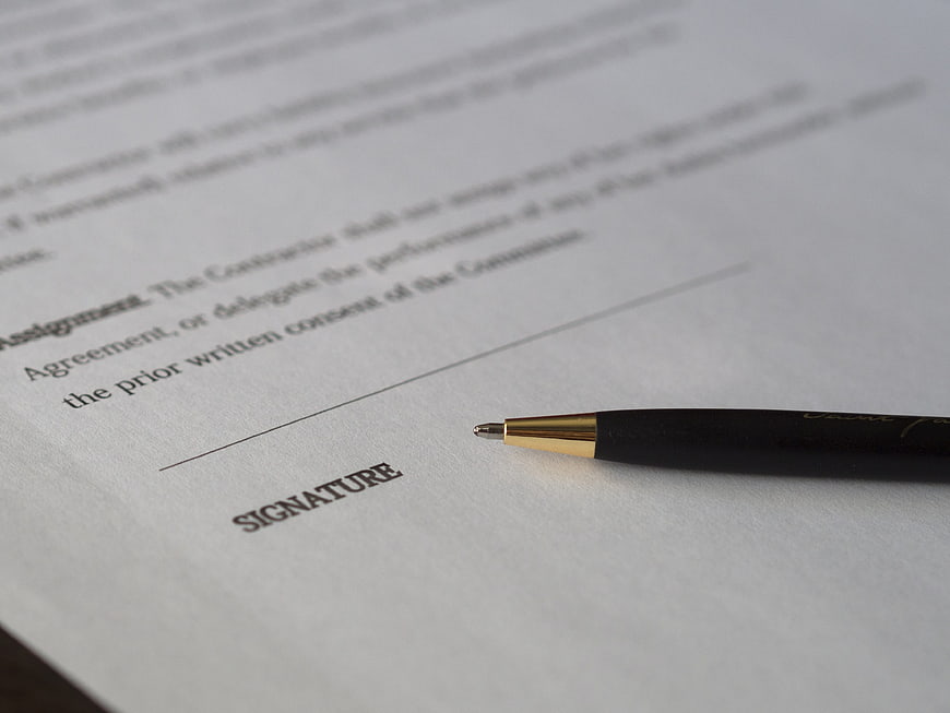 Pen on contract signature line ready for signing