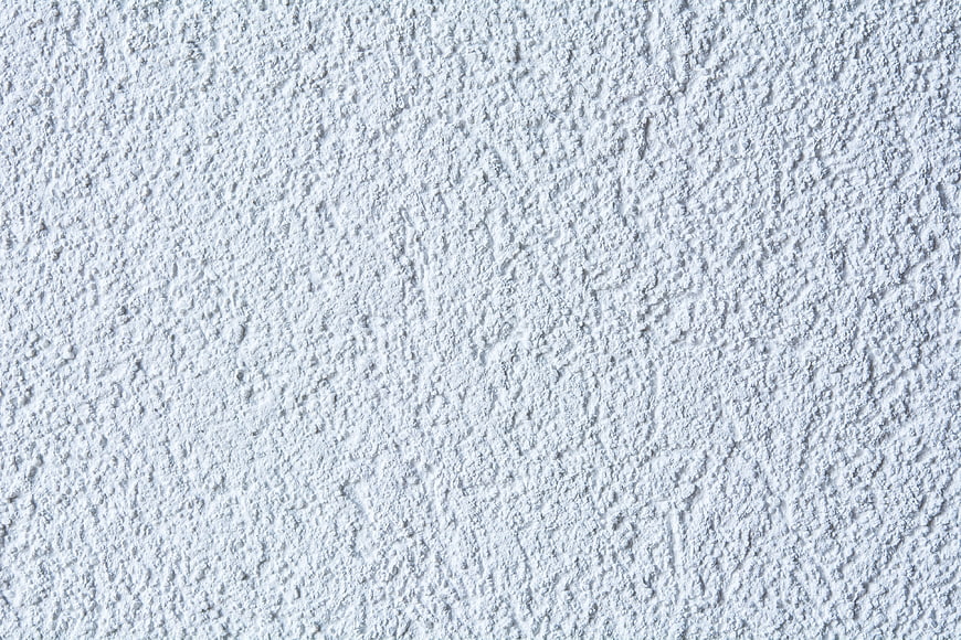 White textured plaster wall background close up