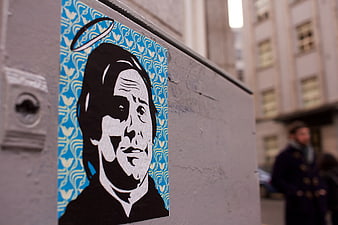 Street Art Sticker of Man with Halo on Urban Wall