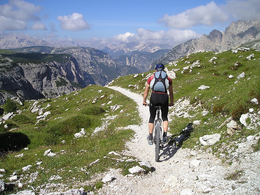 Cyclist riding mountain bike on alpine trail with scenic view