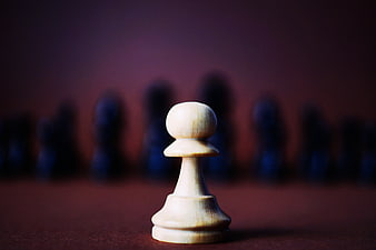 White Chess Pawn Facing Blurred Black Pieces