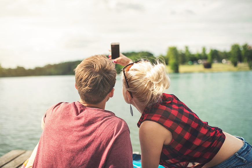 Couple Taking Selfie by Lake on Summer Day