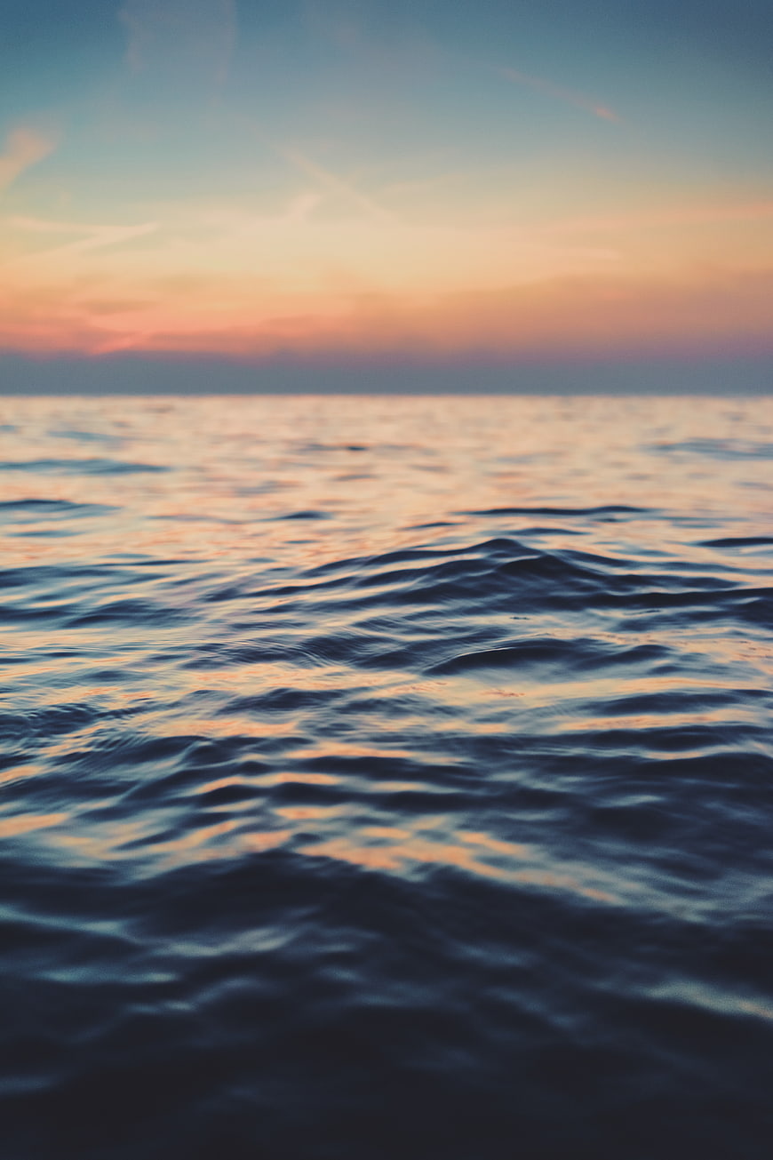 Serene Ocean Sunset with Soft Pink and Blue Sky Reflections