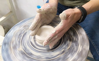 Close-up of hands shaping clay on a spinning pottery wheel