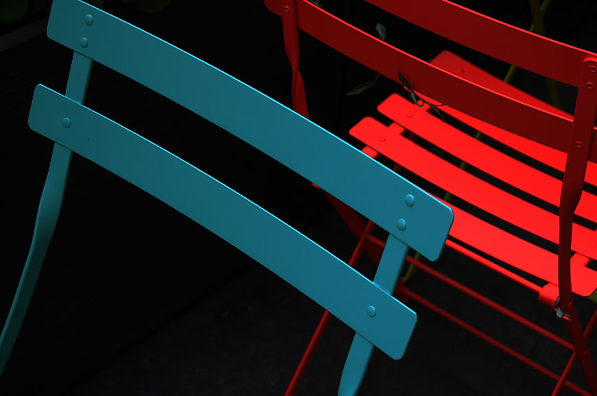 Vibrant Red and Blue Metal Chairs on Dark Background