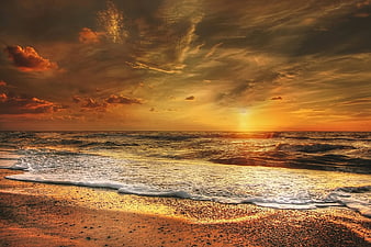Dramatic Golden Sunset Over Ocean Waves on Sandy Beach