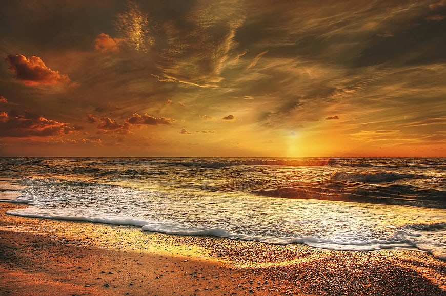 Dramatic Golden Sunset Over Ocean Waves on Sandy Beach