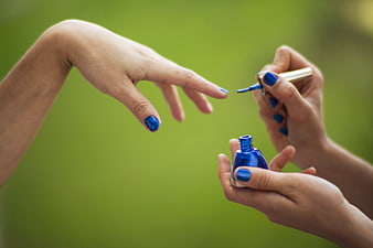 Woman Painting Blue Nails Outdoors