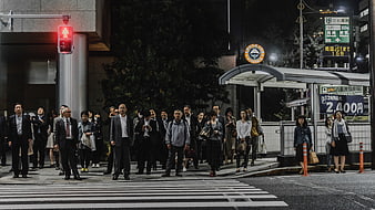 Crowd of Japanese pedestrians waiting at night crosswalk