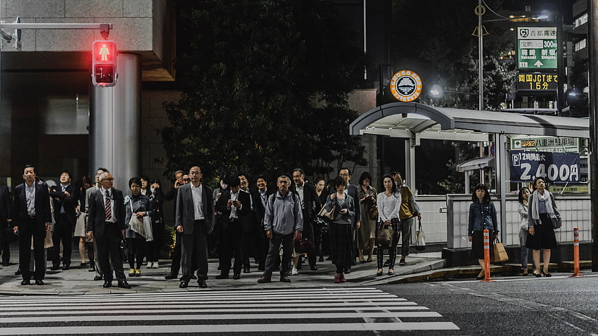 Crowd of Japanese pedestrians waiting at night crosswalk