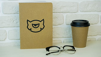 Minimalist workspace with notebook, coffee, and glasses