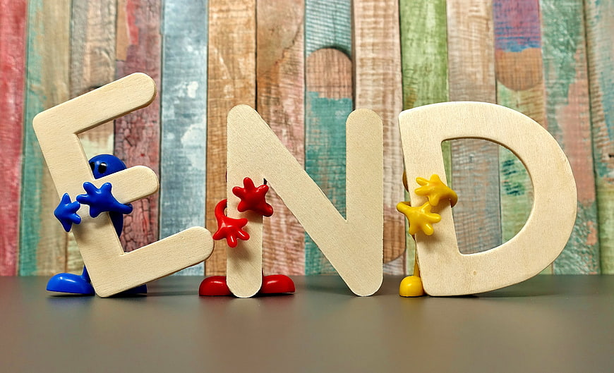 Wooden letters spelling END with colorful toy figures