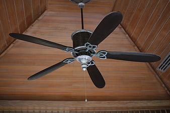 Vintage Five-Blade Ceiling Fan Against Wooden Ceiling