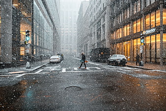 Pedestrian crossing snowy city street in winter