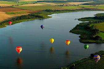 Aerial View of Colorful Hot Air Balloons Over River Landscape