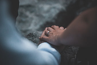 Close-up of couple holding hands with wedding ring