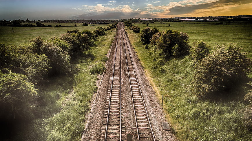Aerial View of Railway Tracks Cutting Through Green Countryside