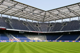 Empty Red Bull Arena stadium with blue seats and green pitch