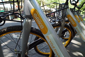 Close-up of Ofo bike sharing bicycles parked on city street