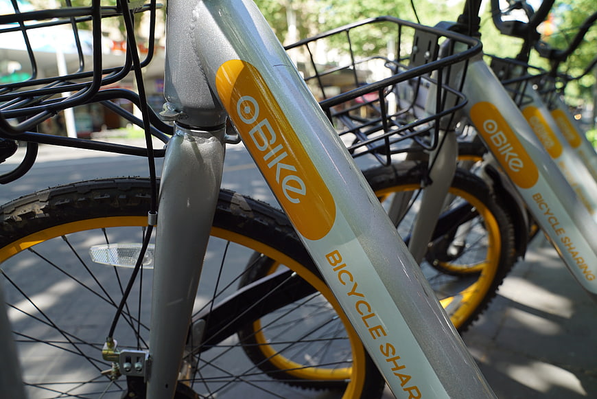Close-up of Ofo bike sharing bicycles parked on city street