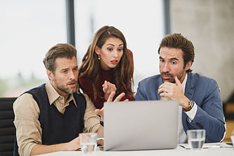 Concerned business team discussing laptop in office meeting