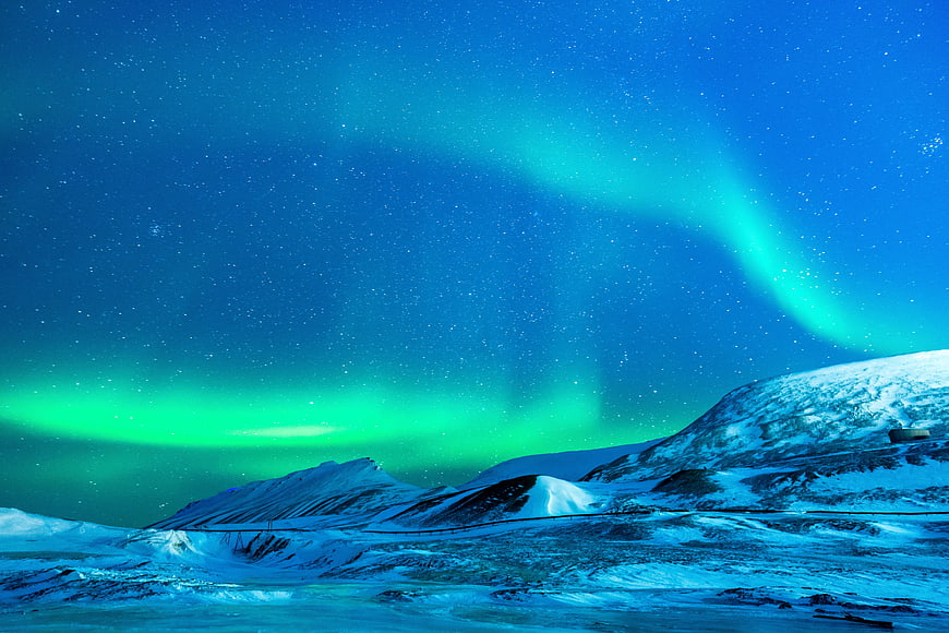 Vibrant Aurora Borealis Over Snowy Arctic Landscape at Night