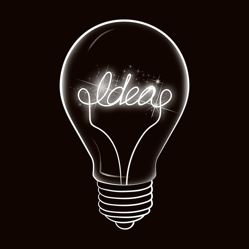 Glowing lightbulb with word ideas inside on black background