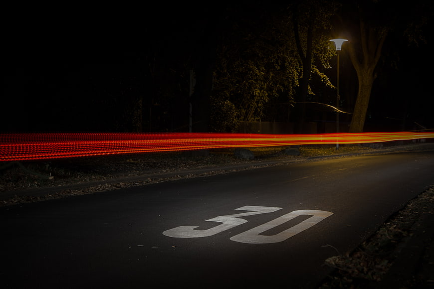 Long Exposure Red Car Light Trails on Night Road