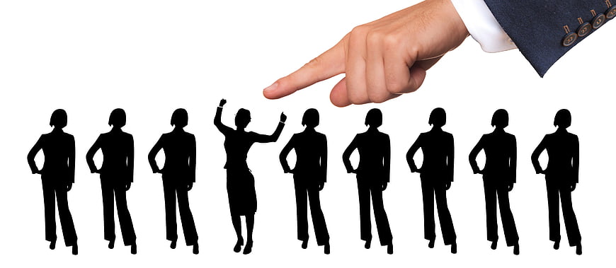 Hand pointing at selected business silhouette from group