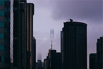Moody cityscape with skyscrapers in fog and mist