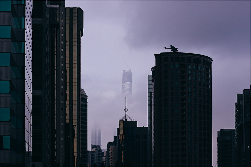 Moody cityscape with skyscrapers in fog and mist