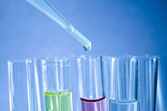 Laboratory Pipette Dropping Liquid Into Colorful Test Tubes
