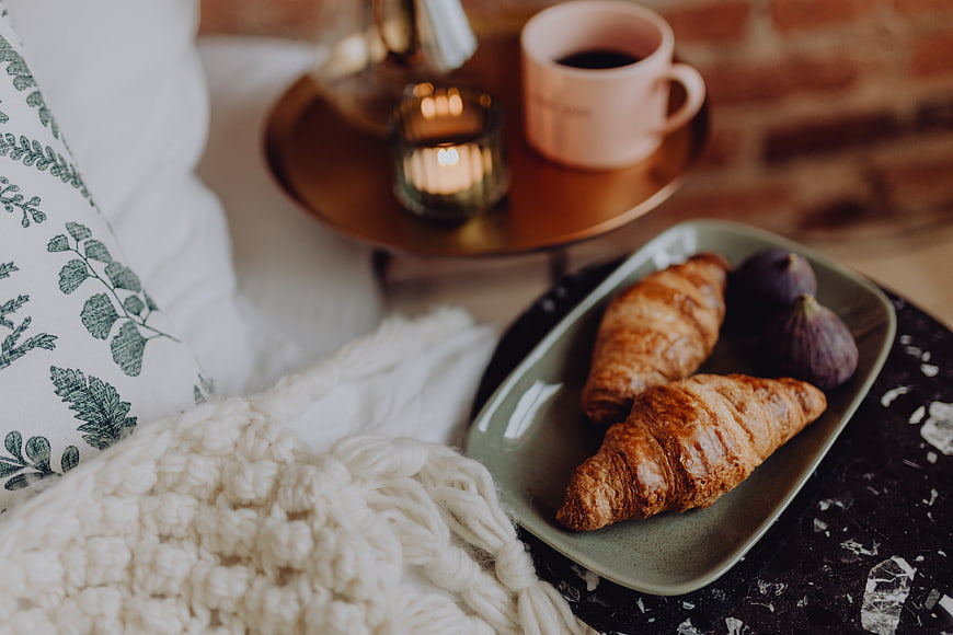 Cozy breakfast with croissants, figs, and coffee on a tray