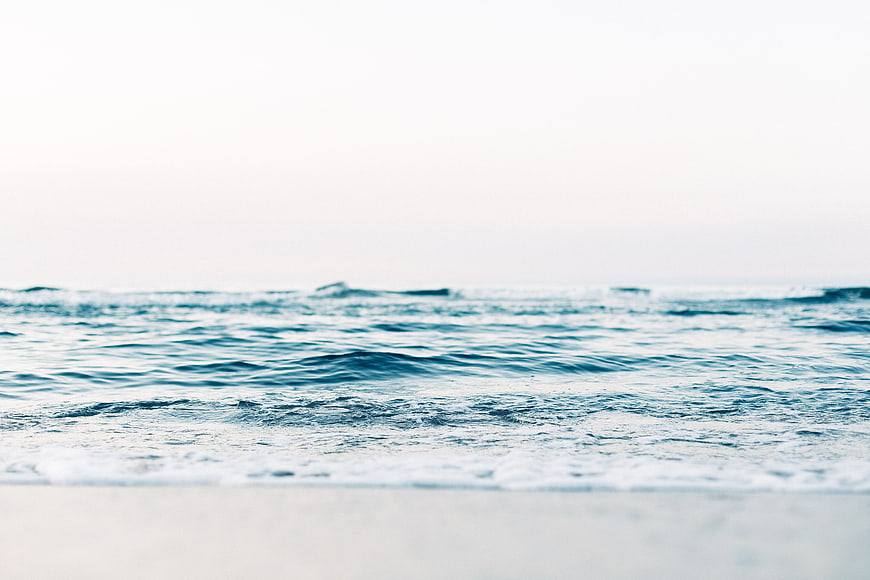 Serene Ocean Waves Washing Over White Sandy Beach Shore