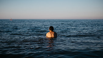 Man Swimming in Ocean at Sunset