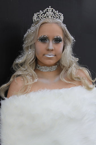 Blonde woman in snow queen costume with tiara and white fur