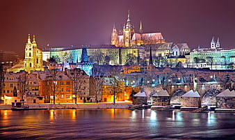 Prague Castle and Charles Bridge illuminated at night in winter