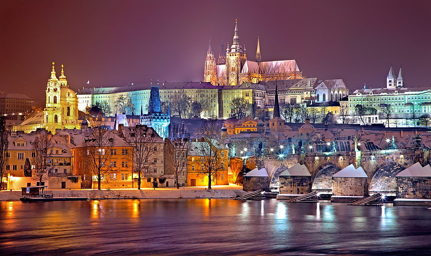 Prague Castle and Charles Bridge illuminated at night in winter