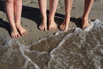 Family Feet Standing On Wet Sand At Beach Shoreline