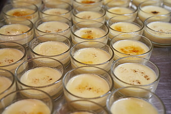 Rows of creamy caramel custard desserts in glass cups