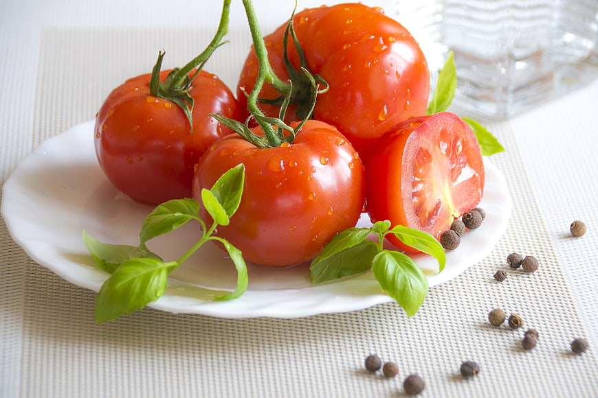 Fresh Red Tomatoes on Vine with Basil and Peppercorns